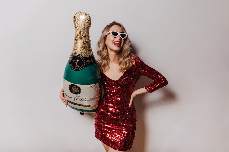 Gratis Bild snygg kvinna i solglasögon som håller en stor champagneflaska. studiobild av kaukasisk tjej i kort röd klänning