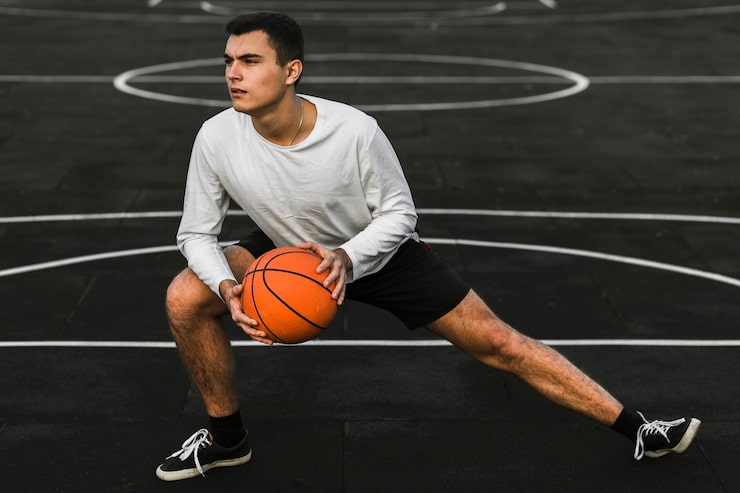 Gratis Bild stilig atlet som stretchar på basketplan