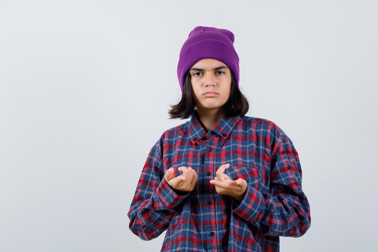 Gratis Foto teenagepige i ternet skjorte og hue gestikulerer isoleret