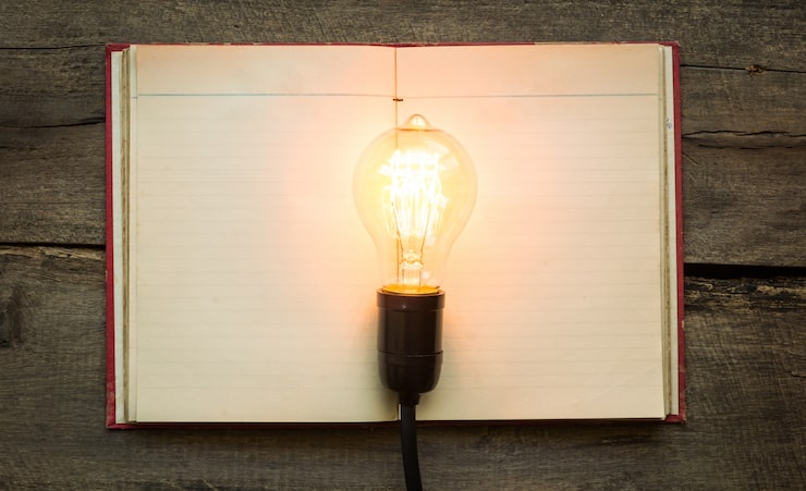 Gratis Bild tom bok med en tänd glödlampa ovanpå