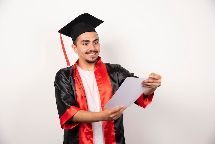Gratis Bild ung utexaminerad student som tittar glatt på diplom på vitt.