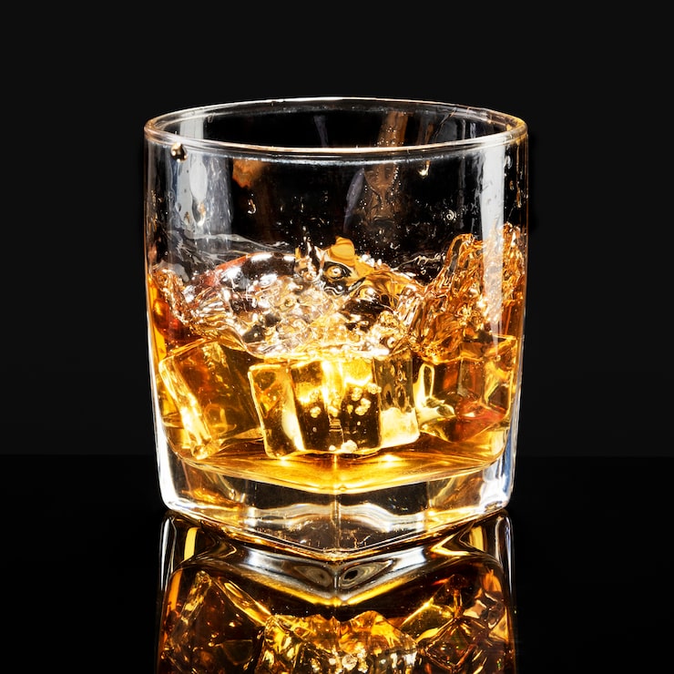 Gratis Bild whiskey med isbitar mot svart bakgrund