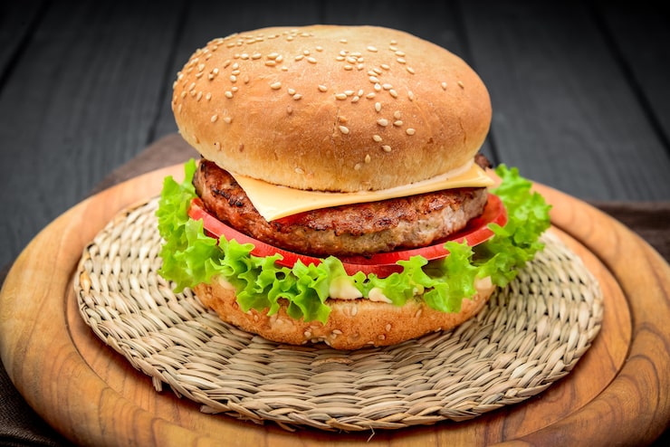 Photo bánh cheeseburger ngon miệng với cà chua trên nền gỗ