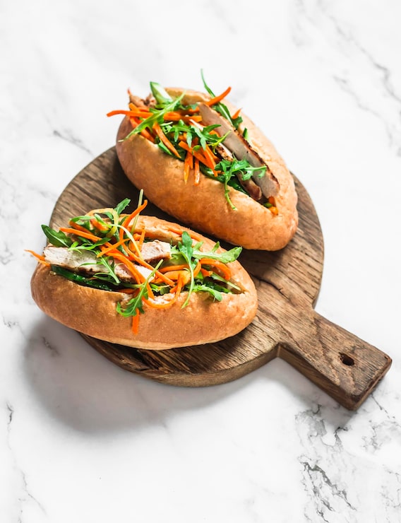 Photo bánh mì kẹp thịt heo banh mi trên thớt trên nền sáng, nhìn từ trên xuống