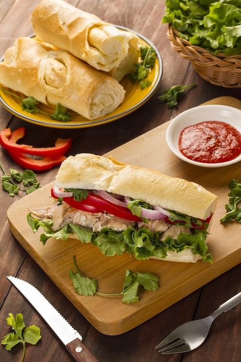 Miễn phí Photo bánh mì baguette kẹp hành tây, ớt, rau diếp và thịt gà nấu chín ăn kèm với tương cà chua