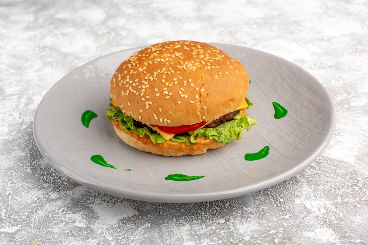 Miễn phí Photo góc nhìn chính diện của bánh mì kẹp gà với rau xà lách xanh và rau củ bên trong đĩa trên bàn sáng