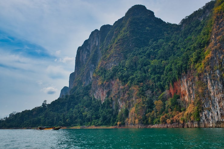 Miễn phí Photo lái thuyền đuôi dài trên hồ khao sok ở thái lan trong khung cảnh núi đá tuyệt đẹp