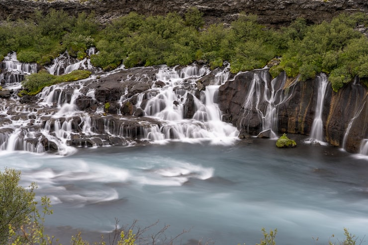 Miễn phí Photo thác nước hraunfossar được bao quanh bởi cây xanh vào ban ngày ở iceland