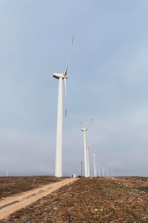 Ilmainen Kuva sivunäkymä monista tuulivoimaloista pellolla tuottamassa energiaa
