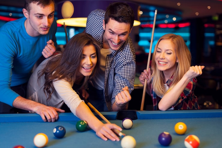 Photo gratuit amis applaudissant pendant que leur ami vise une boule de billard