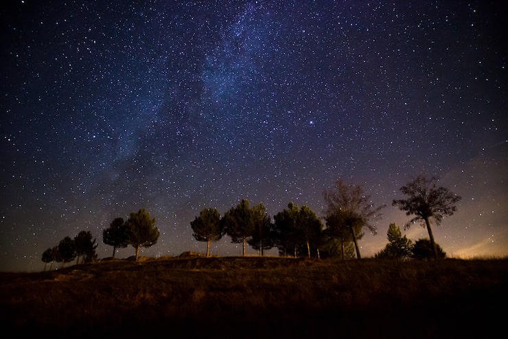 Photo gratuit belle photo de la voie lactée au-dessus d'une colline avec peu d'arbres la nuit