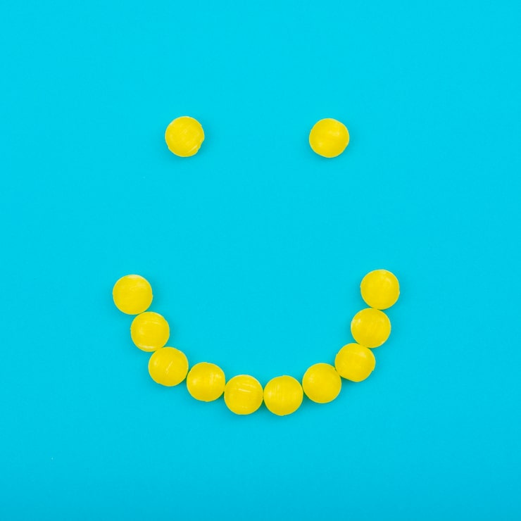 Photo gratuit bonbons à la gelée smiley sur la table bleue