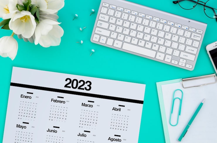Photo gratuit calendrier 2023 vue de dessus avec clavier et fleurs