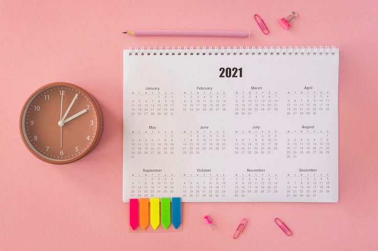 Photo gratuit calendrier de bureau plat laïc sur fond rose