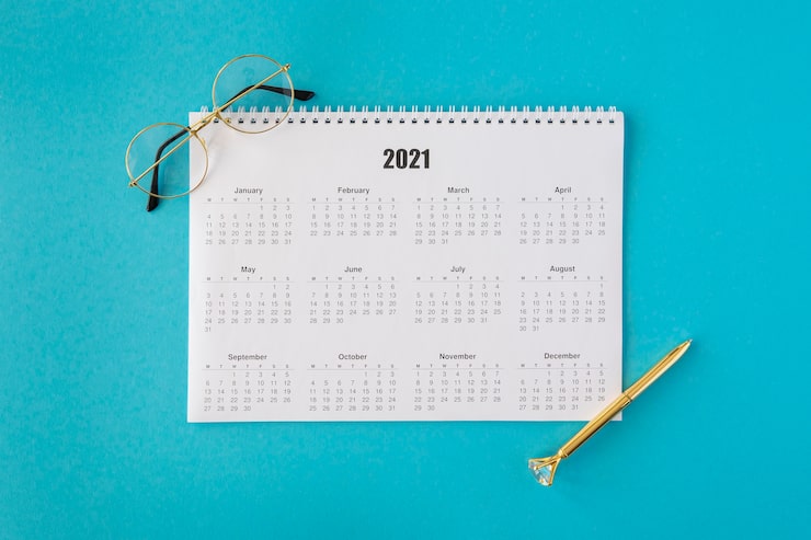 Photo gratuit calendrier de papeterie vue de dessus avec lunettes de lecture