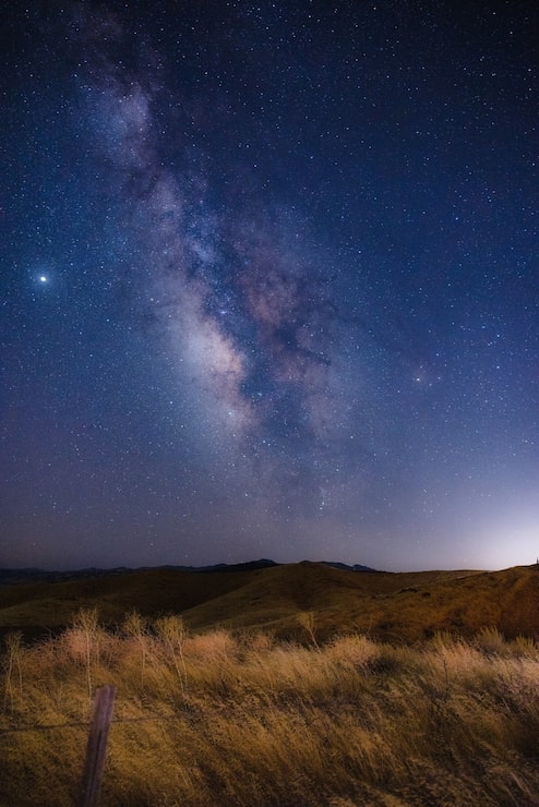 Photo gratuit champ d'herbe brune sous un ciel bleu pendant la nuit