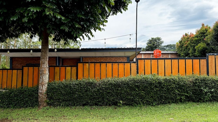 Photo gratuit clôture en bois moderne et haie verte luxuriante dans un paysage de jardin