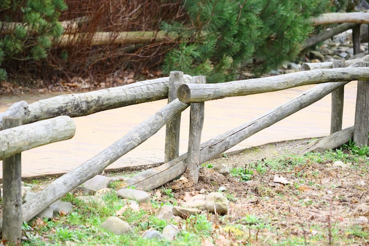 Photo gratuit coup de mise au point sélective d'une clôture en bois près d'un sentier dans le parc