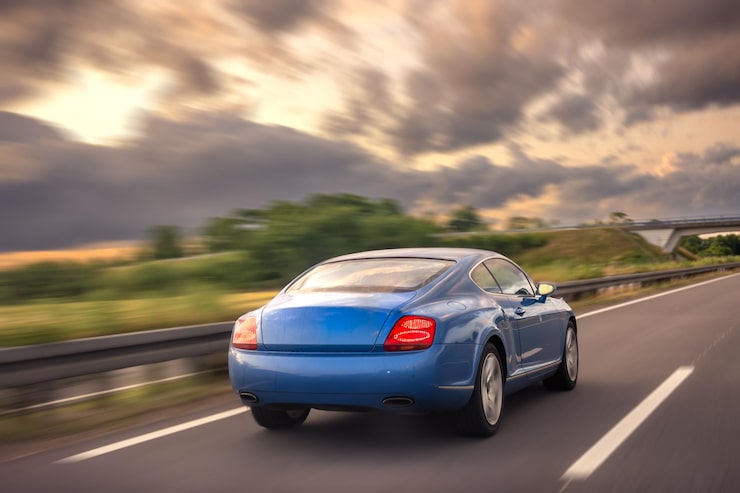 Photo gratuit coupé bleu sur autoroute, vitesse et mouvement au coucher du soleil
