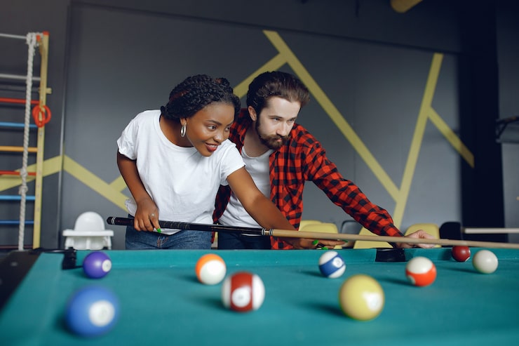 Photo gratuit un couple international joue au billard dans un club.