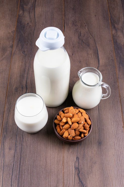 Photo gratuit ensemble de lait et d'amande sur une table sombre et en bois. vue grand angle.