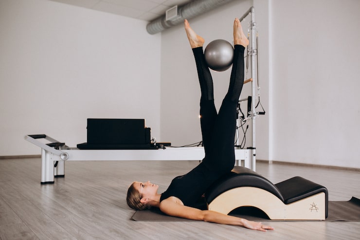 Photo gratuit une femme faisant du pilates avec une balle.