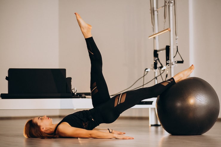 Photo gratuit une femme faisant du pilates avec une balle.