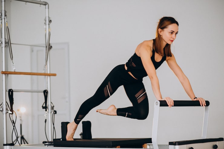 Photo gratuit une femme faisant du pilates sur un réformateur