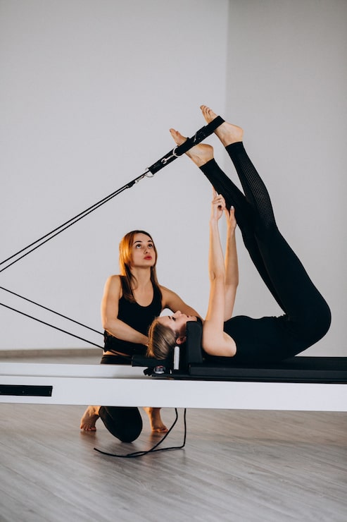 Photo gratuit des femmes faisant du pilates sur un réformateur
