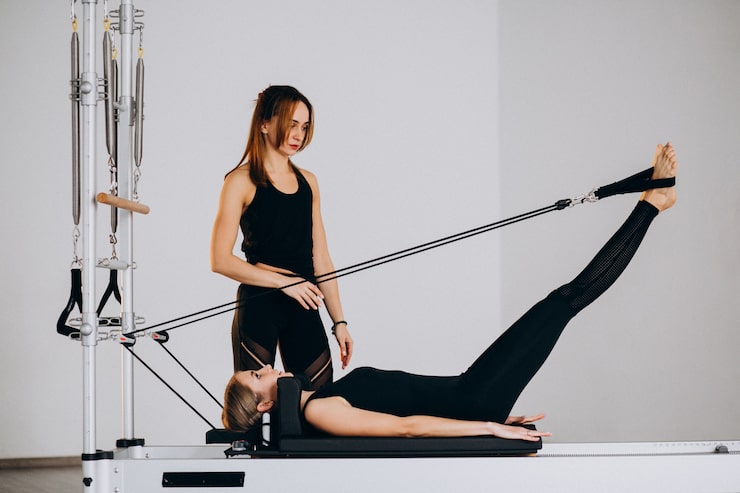 Photo gratuit des femmes faisant du pilates sur un réformateur