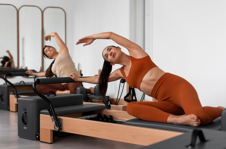 Photo gratuit les gens qui suivent des cours de pilates réformateur