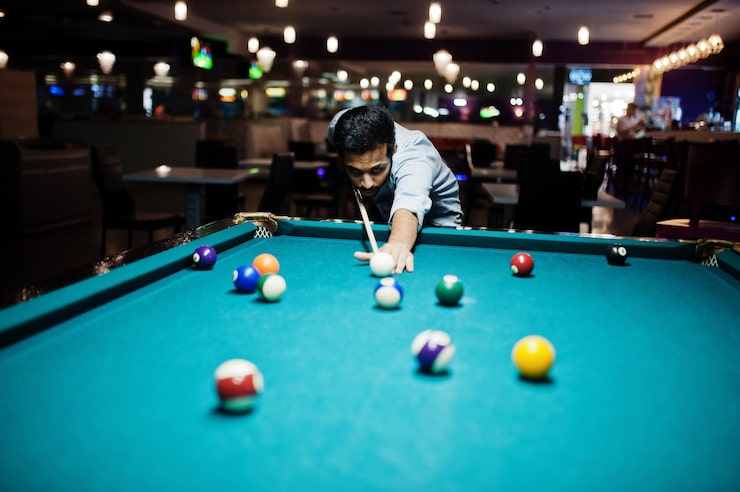 Photo gratuit un homme arabe élégant porte un jean jouant au billard au bar.