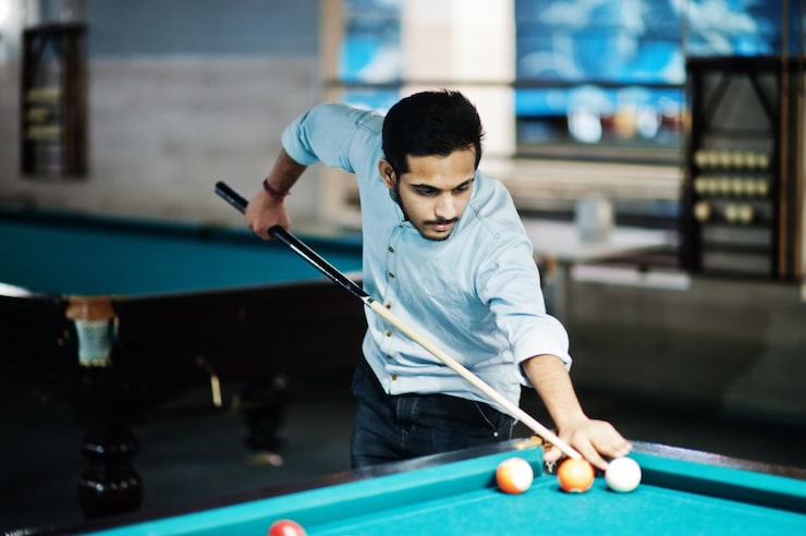 Photo gratuit un homme arabe élégant porte des jeans et joue au billard sur un bar.