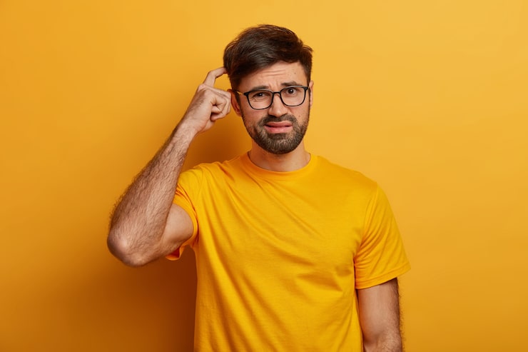 Photo gratuit un homme indécis perplexe se gratte la tête, n'a aucune idée