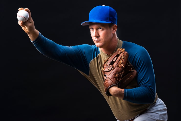 Photo gratuit joueur de baseball posant avec un gant et une balle