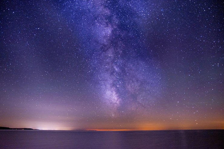 Photo gratuit une photo à couper le souffle de la mer sous un ciel sombre et violet rempli d'étoiles