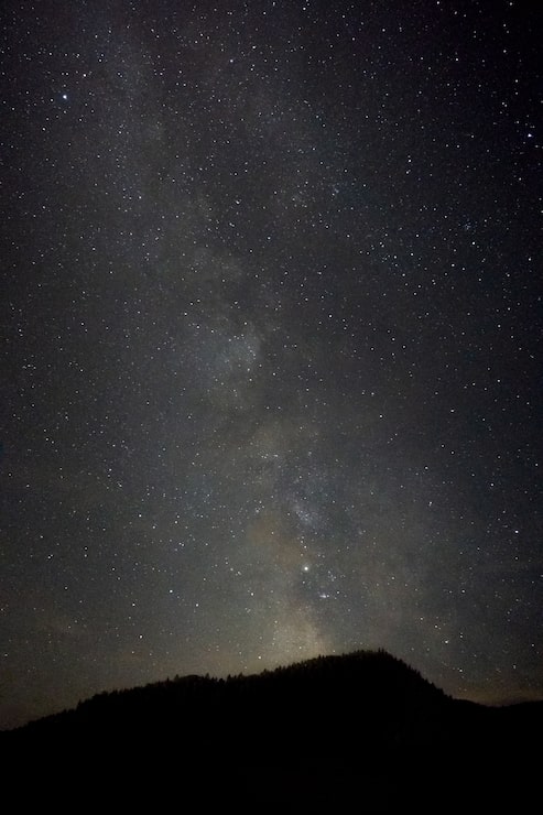 Photo gratuit prise de vue verticale d'une colline avec un paysage à couper le souffle de la galaxie de la voie lactée