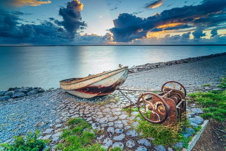 Photo gratuit vieux bateau de pêche rouillé sur la pente le long de la rive du lac