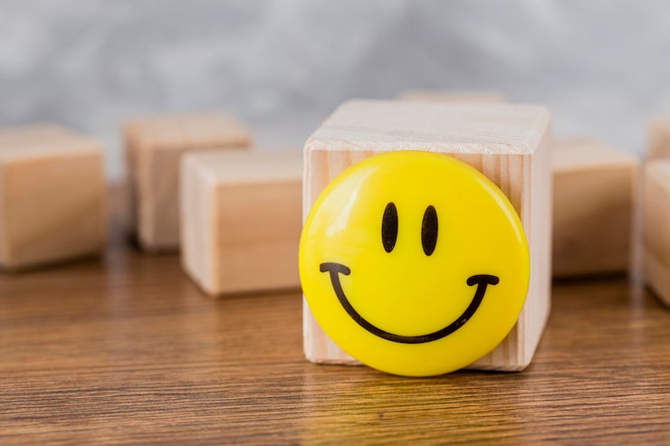 Photo gratuit vue de face du visage souriant sur bloc en bois
