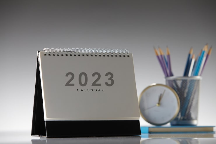 Photo calendrier de bureau 2023 et réveil sur fond gris
