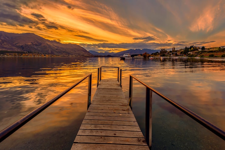 Photo une jetée en bois menant à un lac tranquille au coucher du soleil