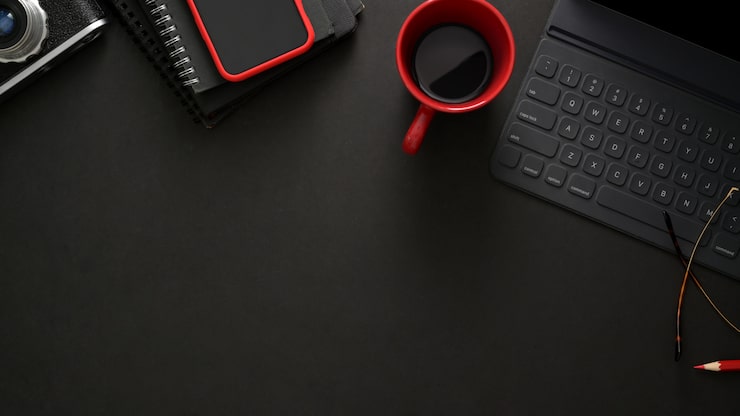 Photo lieu de travail élégant avec clavier sans fil, smartphone, espace copie et tasse de café sur tableau noir