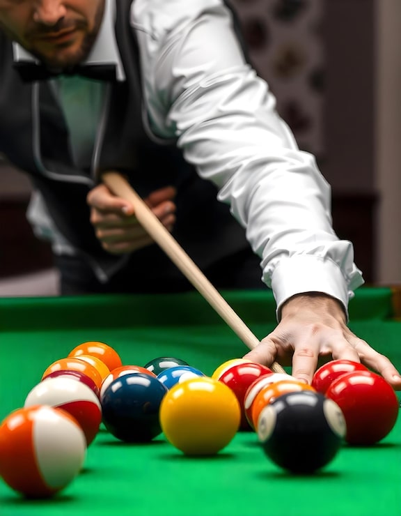 Photo la main de l'homme et le bras de cue jouant au billard ou se préparant à tirer des balles de billard sur un billard vert