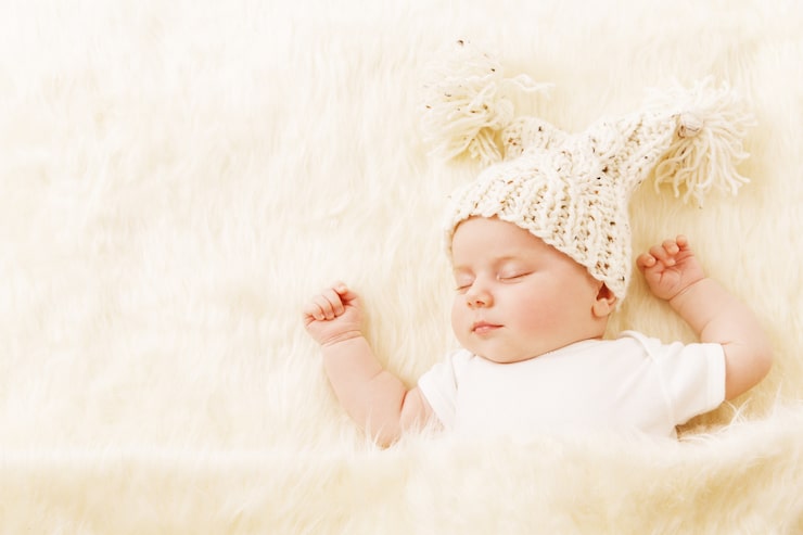 Foto baby sover, nyfødt barn portræt sovende i hat, nyfødt på tæppe, en måned pige sover i seng