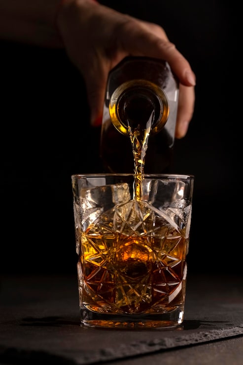 Bild bartender häller whisky eller rom i ett glas