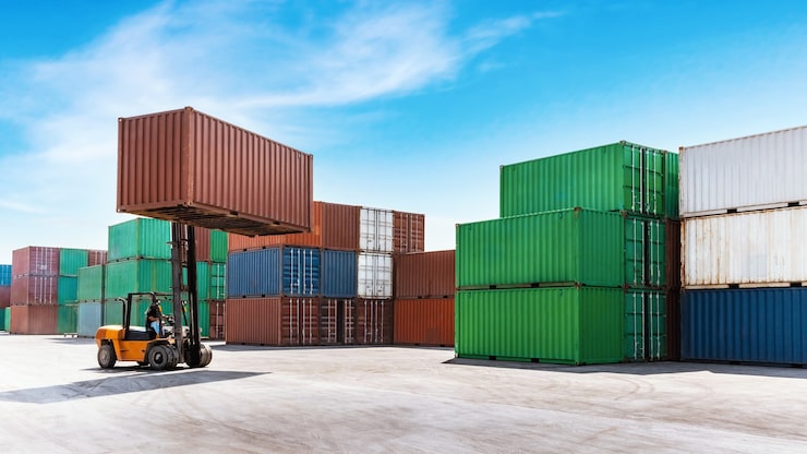 Foto container stabler last med gaffeltruck, der arbejder i en shipping havn.