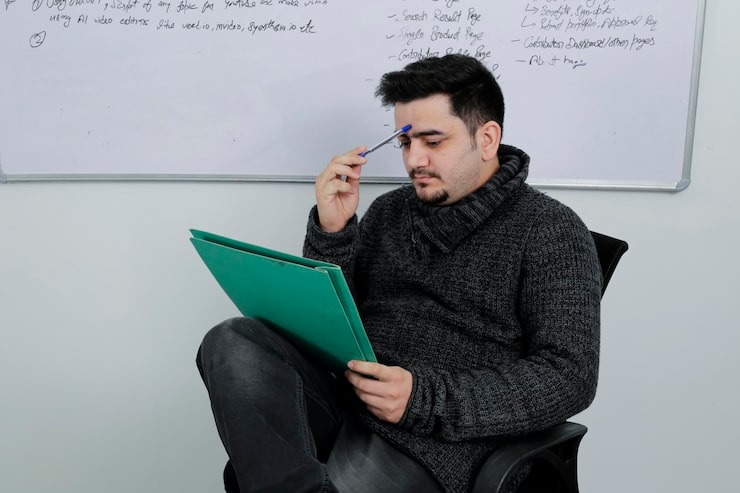 Bild en ung lärare sitter i klassrummet och känner sig stressad.