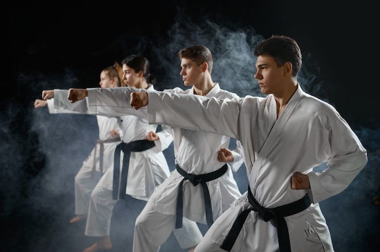 Bild fyra karatekämpar poserar i vit kimono, gruppträning. karatekämpar tränar, kampsport