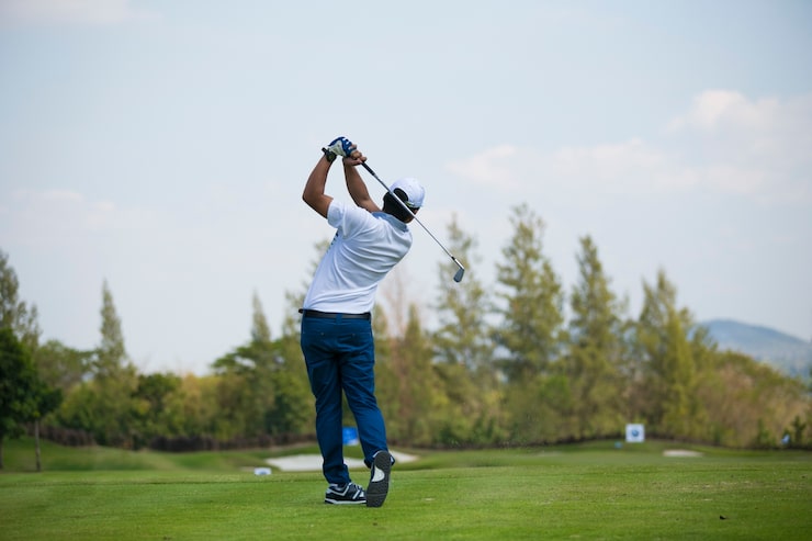 Bild golfare slår svepande golfbana på sommaren