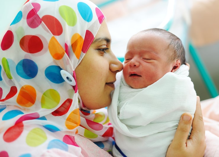 Foto smuk nyfødt baby i sin mors hænder.